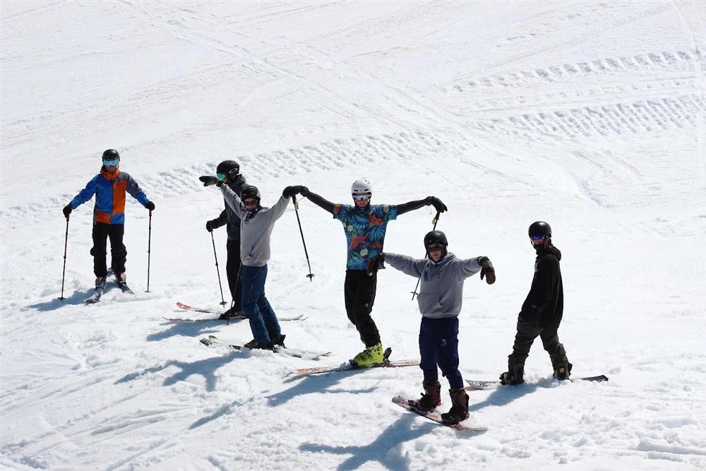 Seks personar på ski og snøbrett står i snøen. - Klikk for stort bilde