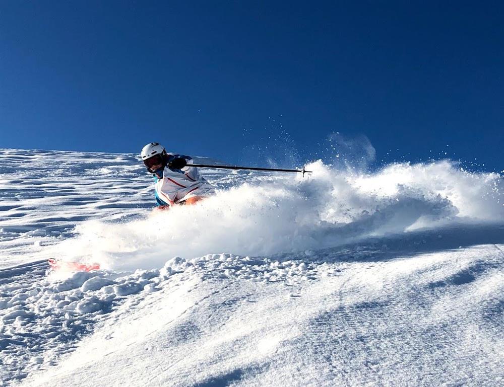 Ein person svinger på ski så snøen sprutar mot kamera. - Klikk for stort bilde